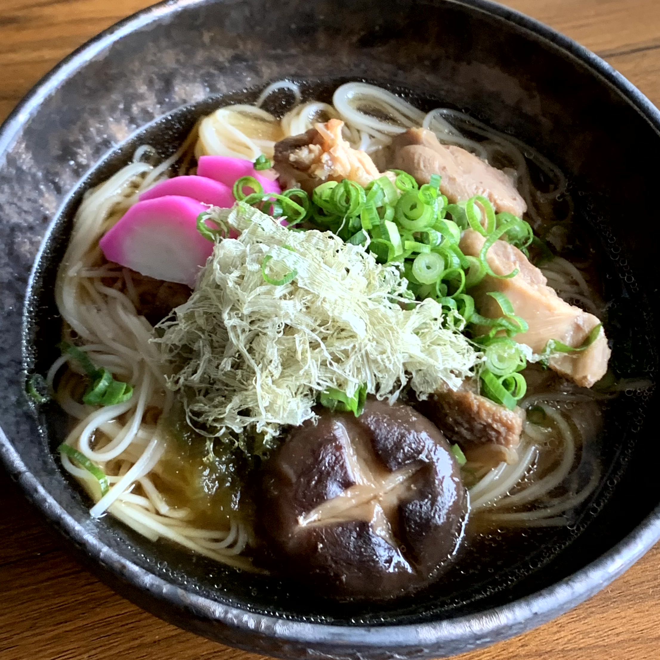 A dish of somen noodles in a warm soup rich in the flavor of shiitake mushrooms.