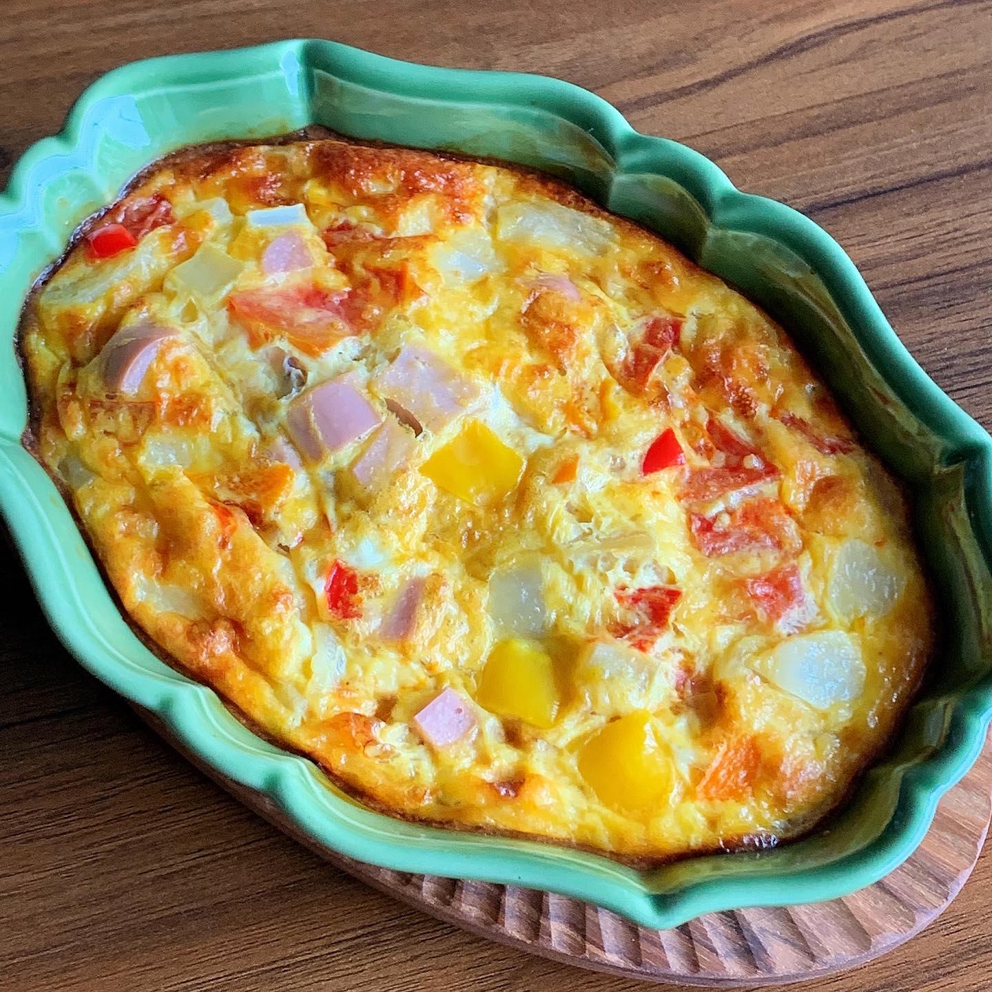 An omelet with ingredients such as paprika, potatoes, and fish sausage.