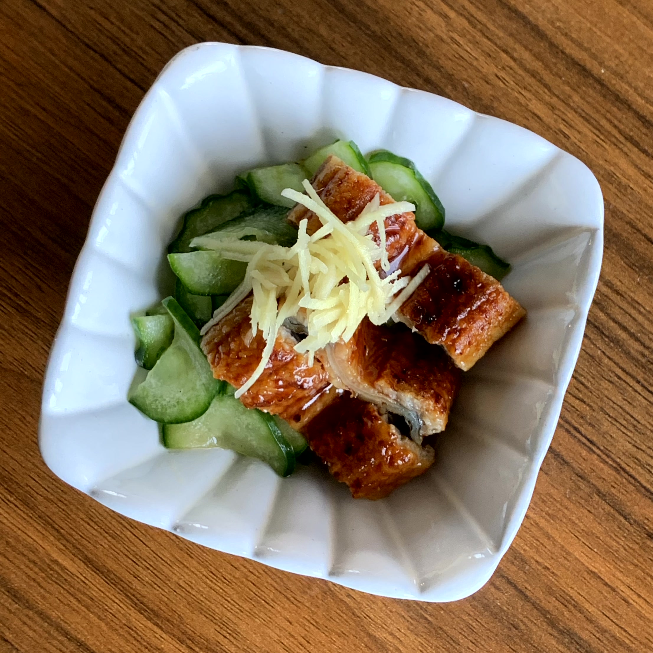 A dish of glaze-grilled eel and cucumbers marinated in vinegar.
