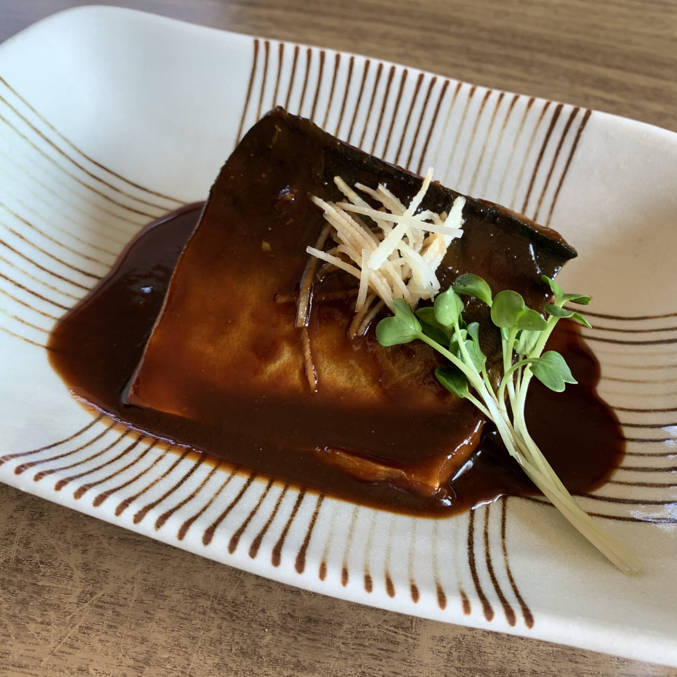 Simmered mackerel and seasoned with red miso．