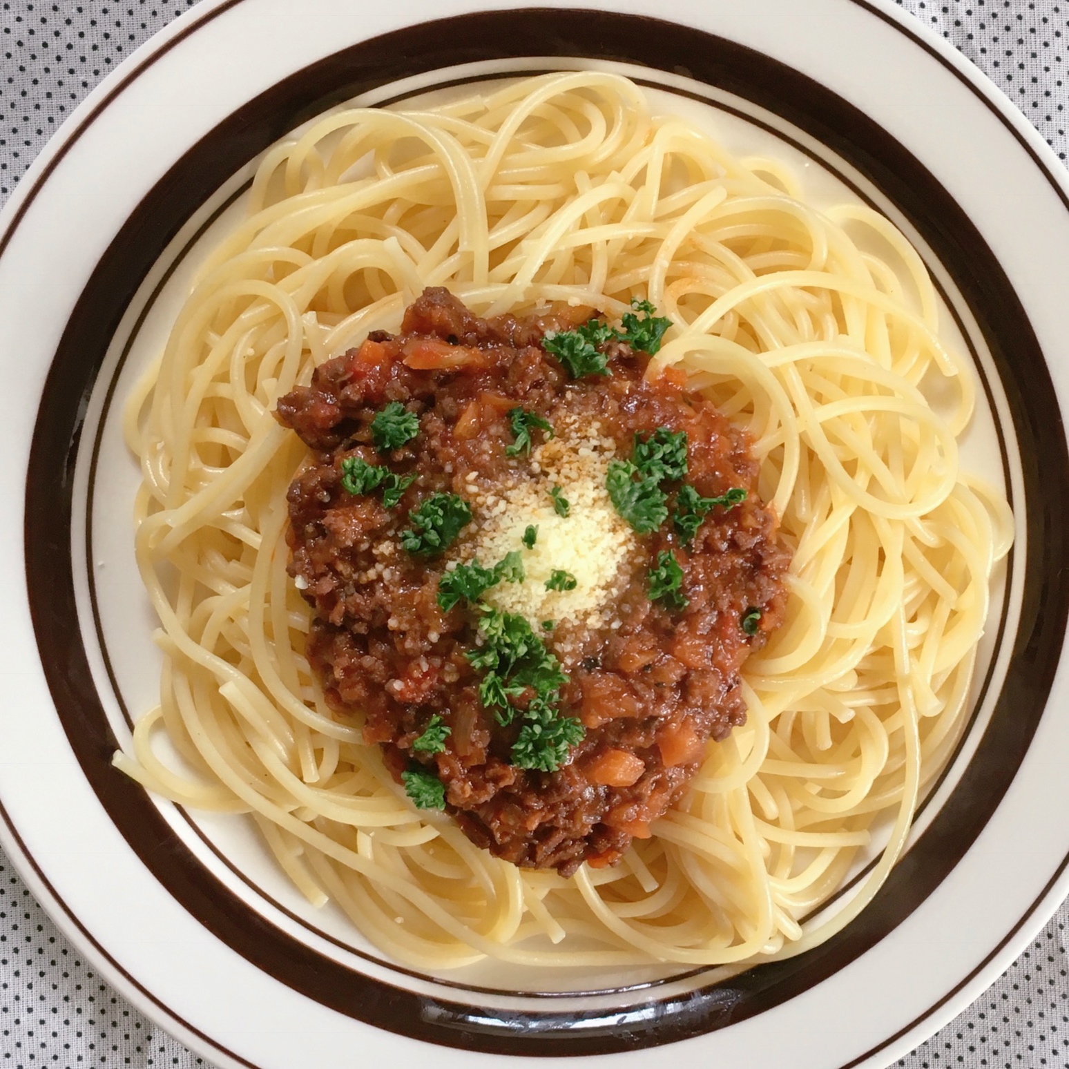 A dish of spaghetti topped with plenty of flavorful meat sauce.