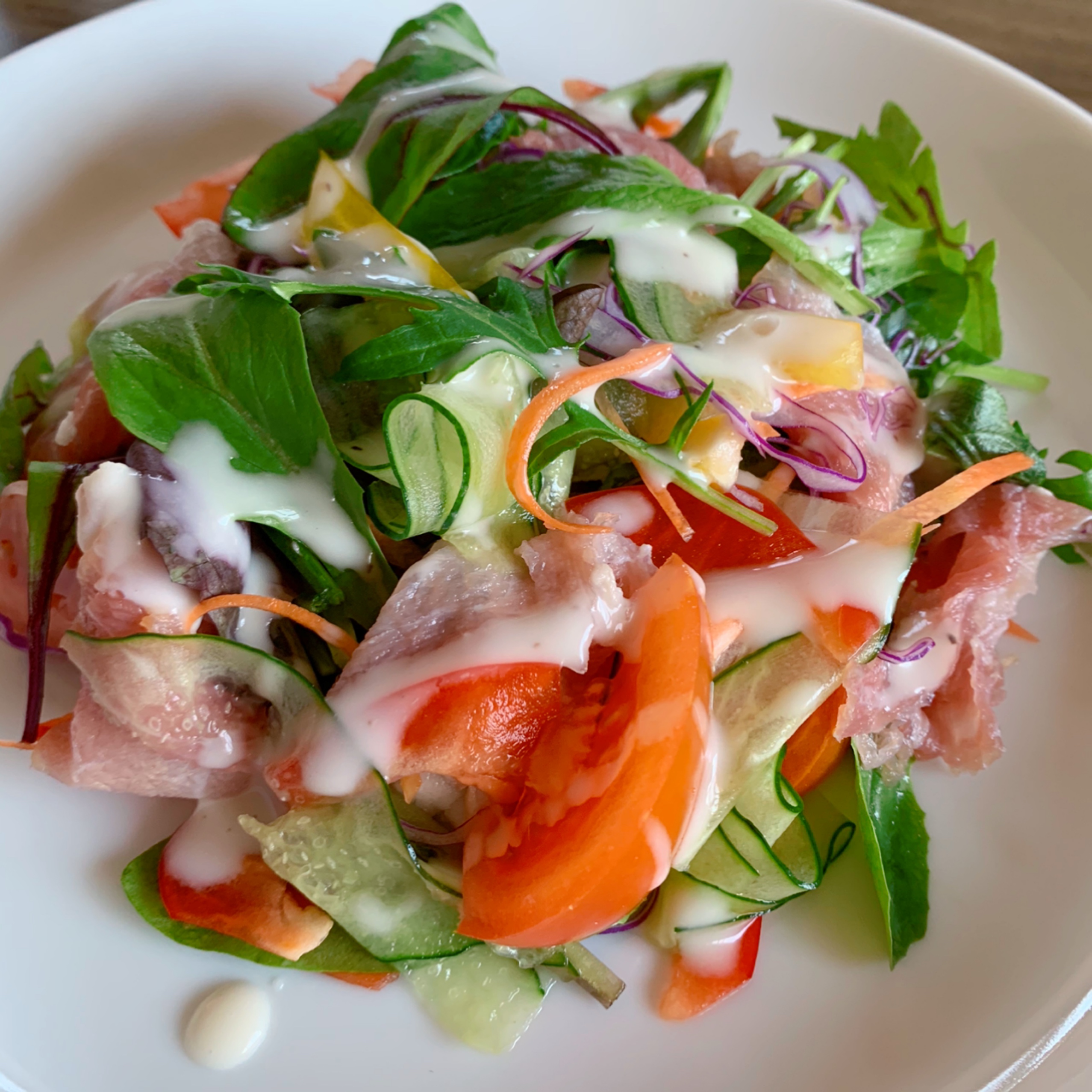 A salad made with plenty of dry-cured ham and baby leaves.