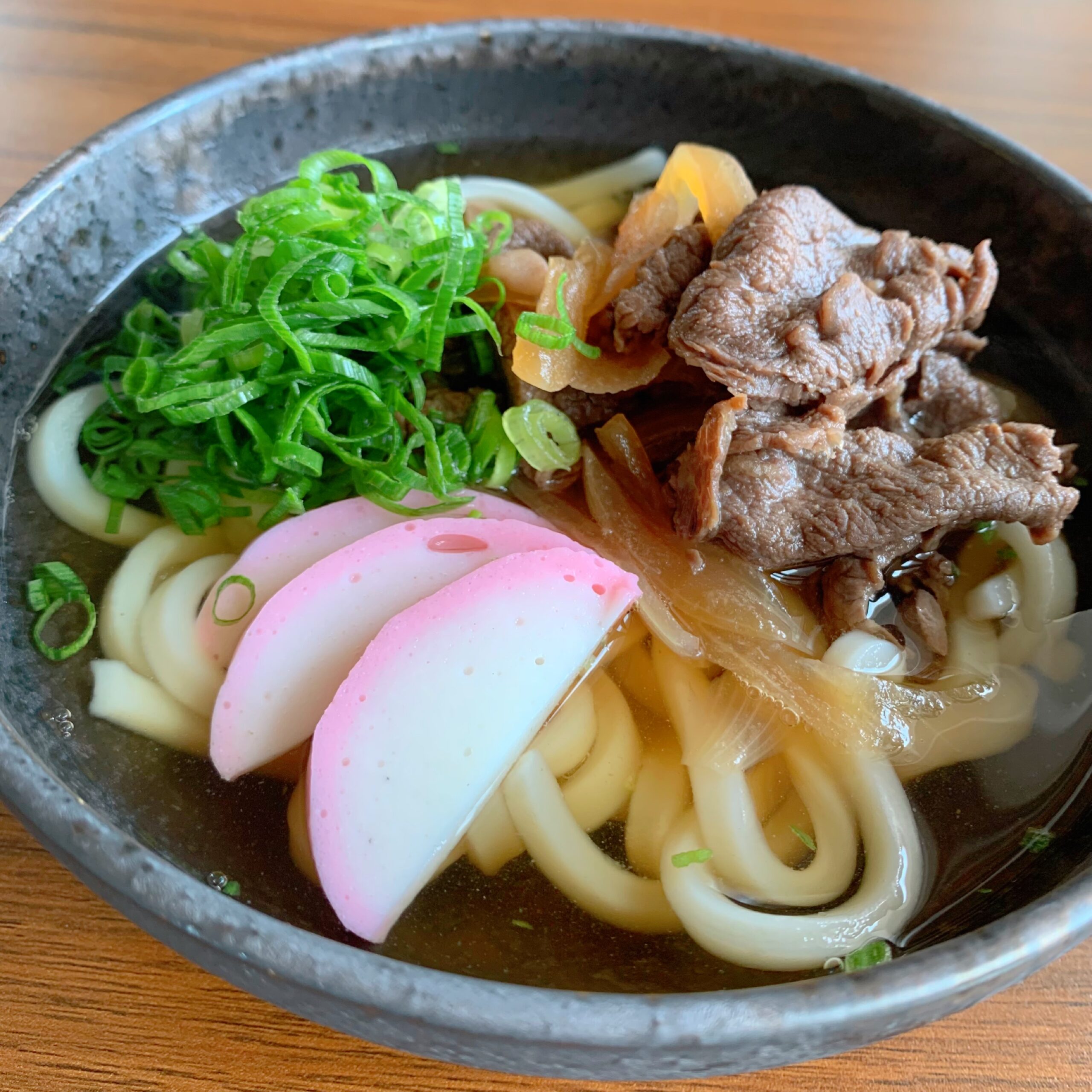 Beef seasoned with soy sauce and sugar is placed on udon noodles. 