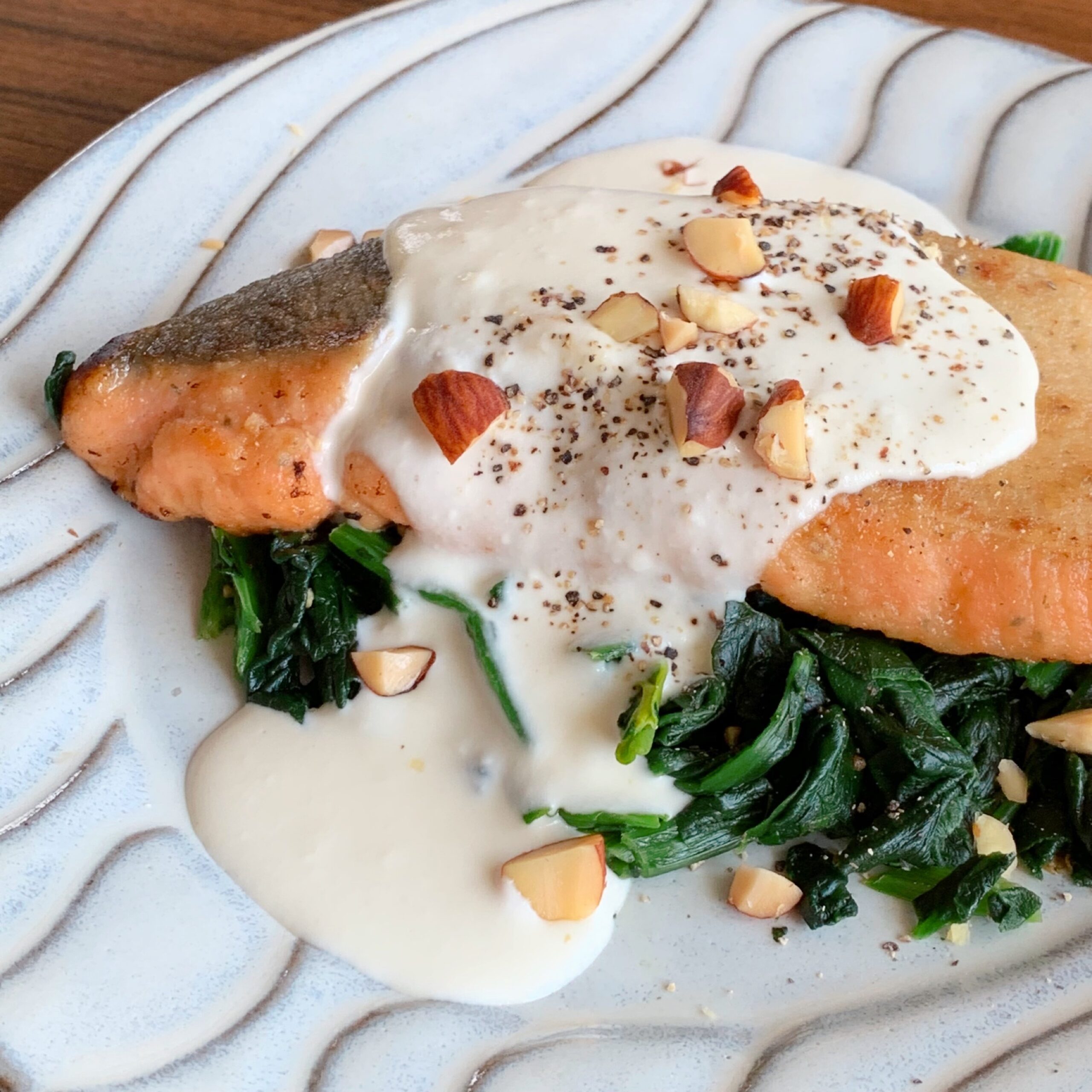 Salmon Meuniere, a classic fish dish, topped with a sauce made from cream cheese.