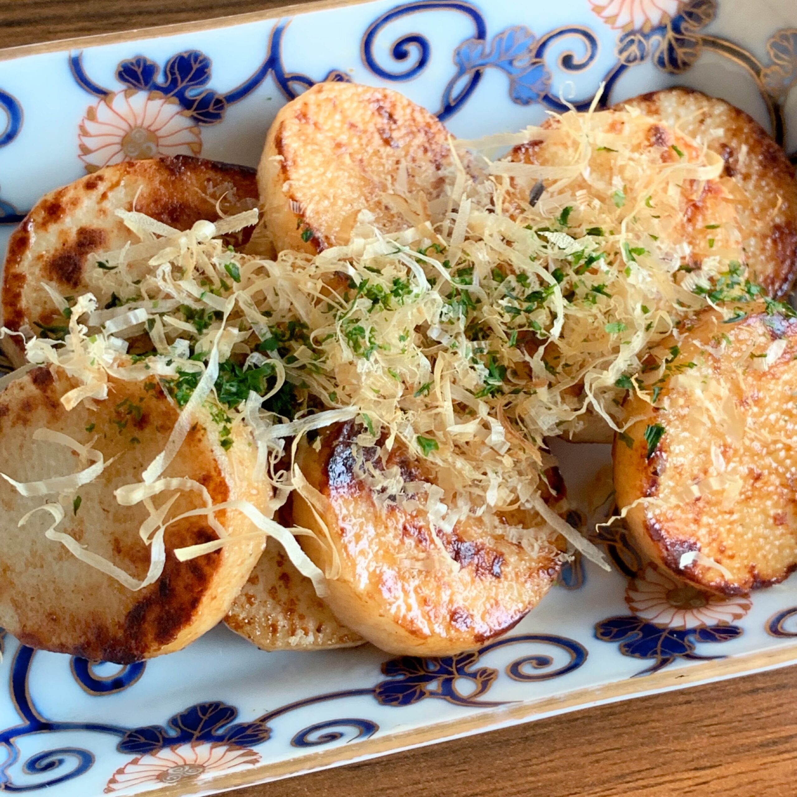 The butter-roasted yam is topped with soy sauce, bonito flakes, and green laver.