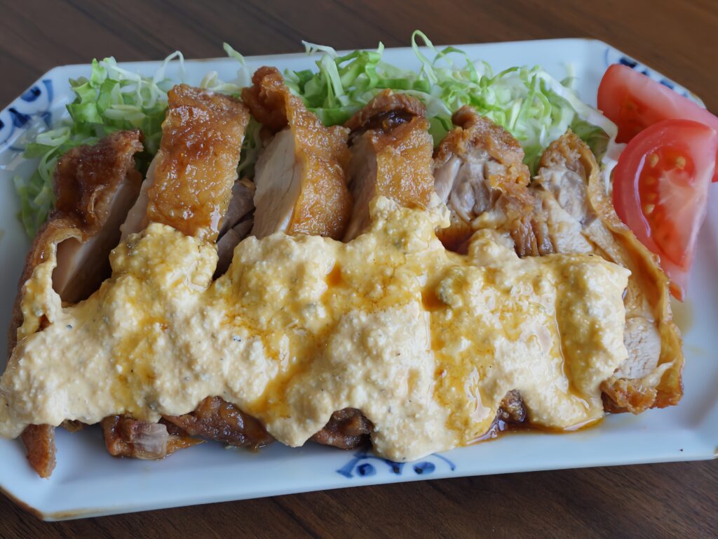 Chicken nanban is fried chicken marinated in a sweet and sour sauce and topped with tartar sauce.